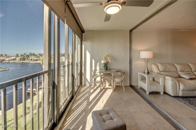 sunroom / solarium featuring ceiling fan and a water view