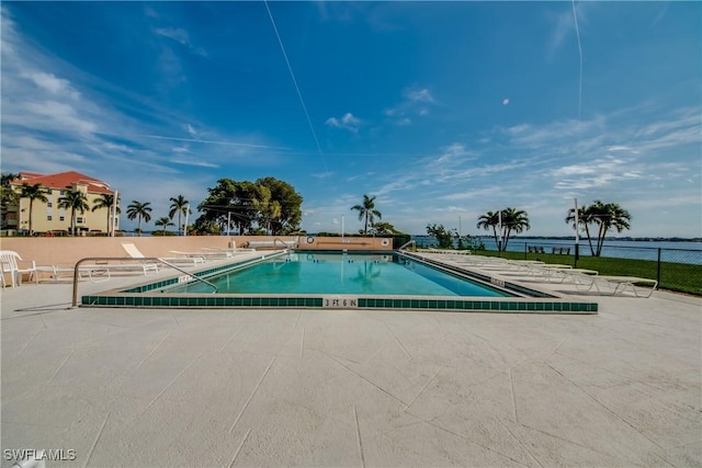 view of pool featuring a water view and a patio area