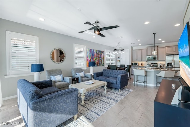 living room featuring ceiling fan with notable chandelier and light tile patterned flooring