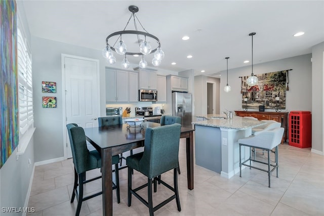 dining room featuring a notable chandelier, light tile patterned floors, and sink