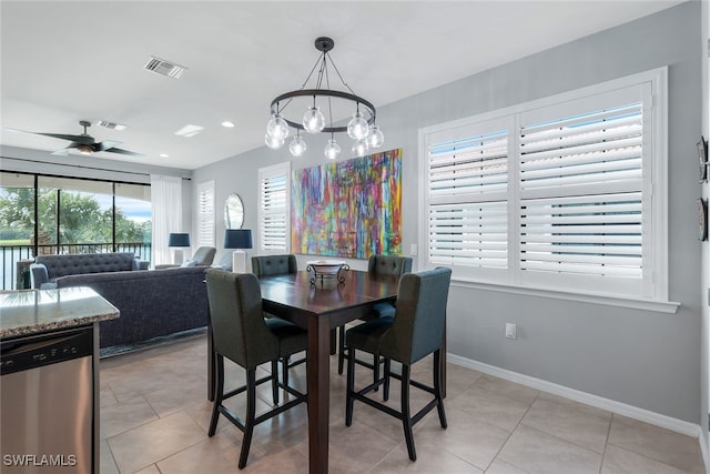 tiled dining room featuring ceiling fan with notable chandelier and plenty of natural light