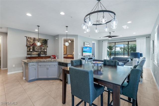 dining space featuring ceiling fan with notable chandelier, light tile patterned floors, and sink