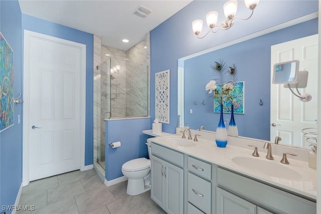 bathroom with toilet, vanity, tile patterned floors, a shower with shower door, and an inviting chandelier