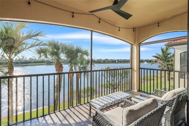 sunroom / solarium featuring ceiling fan and a water view