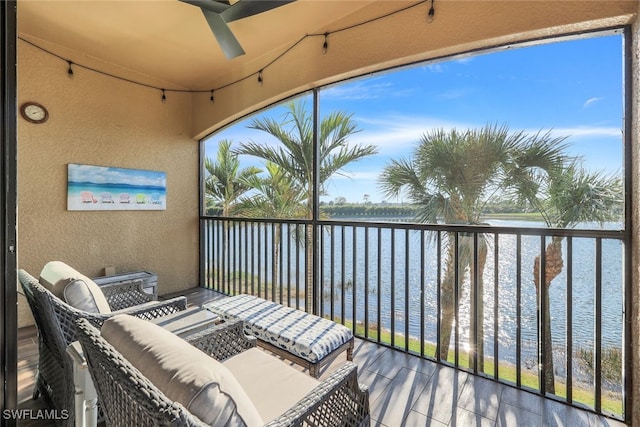 balcony with ceiling fan and a water view