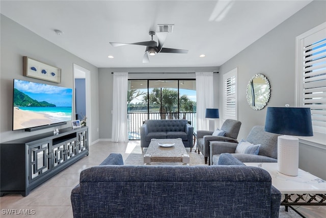 tiled living room with ceiling fan and plenty of natural light