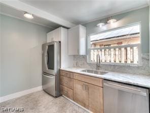 kitchen featuring decorative backsplash, sink, stainless steel appliances, and white cabinetry