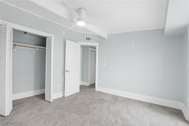 unfurnished bedroom with ceiling fan, a closet, and beam ceiling