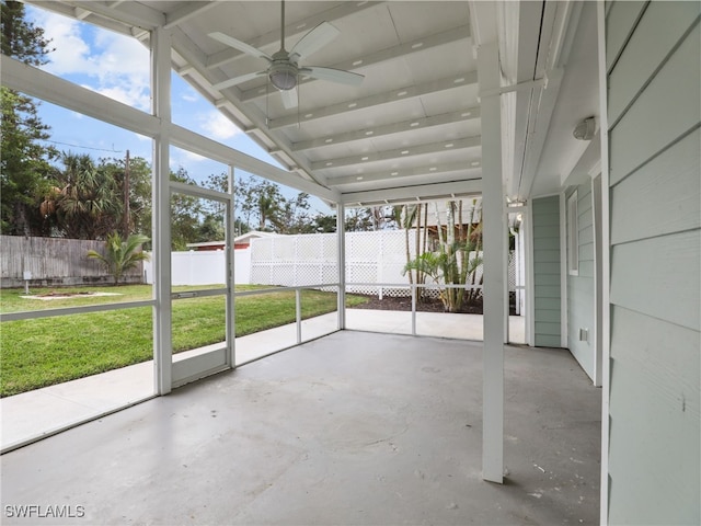 unfurnished sunroom featuring a ceiling fan, lofted ceiling, and a healthy amount of sunlight