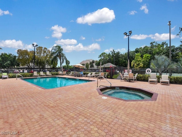 view of swimming pool featuring a hot tub and a patio