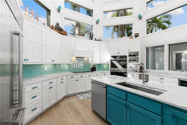 kitchen featuring sink, a high ceiling, white cabinetry, and appliances with stainless steel finishes