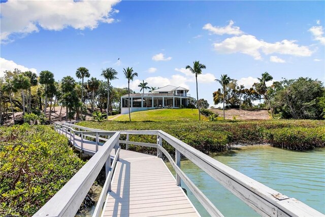 dock area with a lawn and a water view