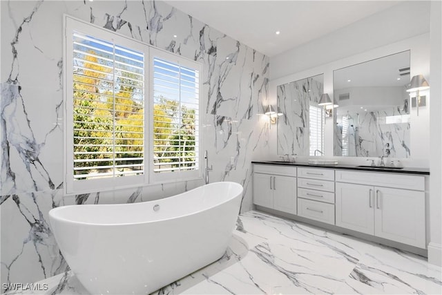 bathroom featuring tile walls, a tub, and vanity