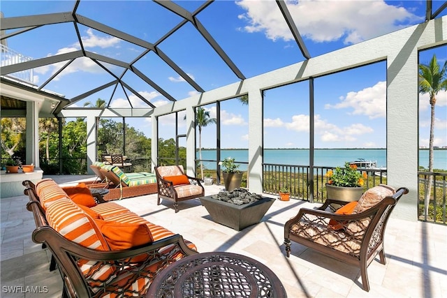 view of patio / terrace featuring a lanai, an outdoor living space, and a water view