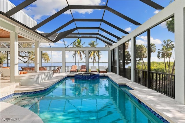 view of swimming pool with a patio area, glass enclosure, an in ground hot tub, and a water view