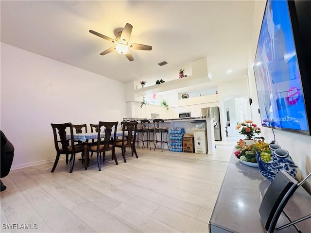 dining area with ceiling fan and light hardwood / wood-style floors