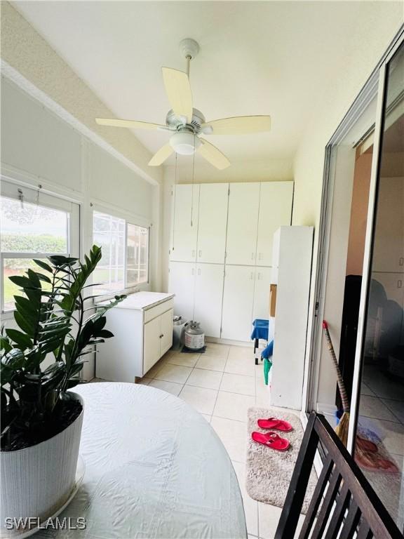 tiled bedroom with ceiling fan and a closet