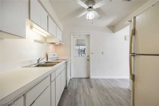 kitchen with white appliances, light wood-type flooring, white cabinets, ceiling fan, and sink