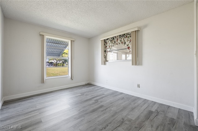 empty room with a textured ceiling and wood-type flooring