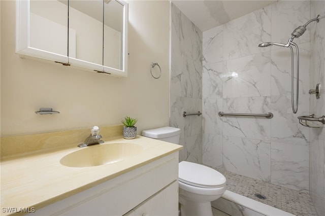 bathroom with toilet, a tile shower, and vanity