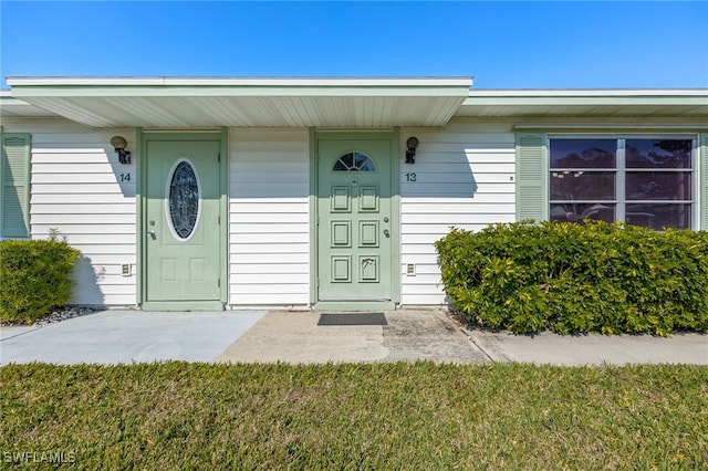 entrance to property with a lawn