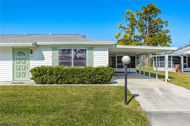 view of front facade with a front yard and a carport