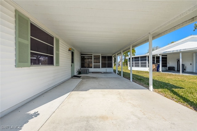 view of patio with central AC unit, a carport, and a sunroom