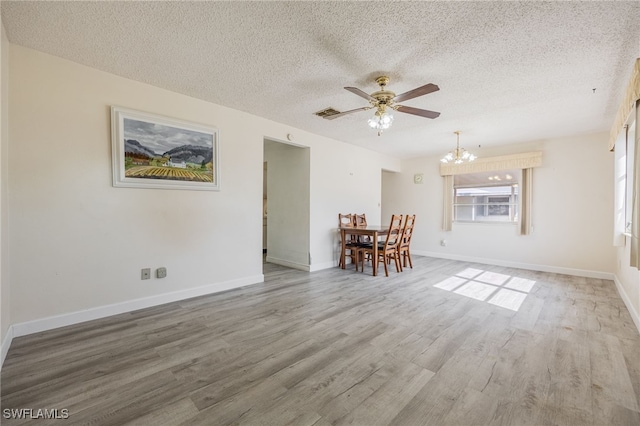 interior space with ceiling fan with notable chandelier, a textured ceiling, and wood-type flooring