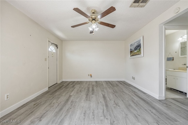 interior space with light hardwood / wood-style floors, ceiling fan, and a textured ceiling