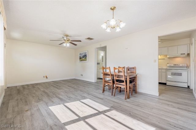 unfurnished dining area featuring light hardwood / wood-style floors, a textured ceiling, and ceiling fan with notable chandelier