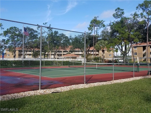 view of tennis court with a yard