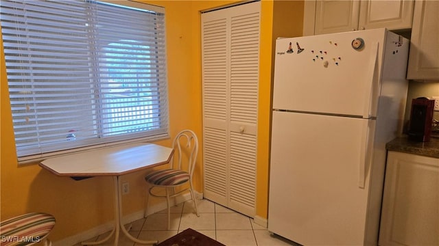 kitchen featuring light tile patterned floors and white fridge