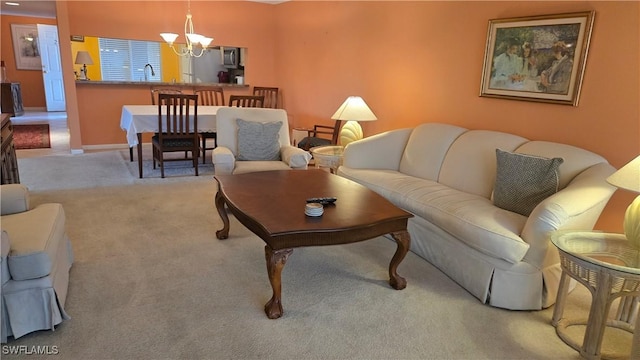 carpeted living room with sink and a chandelier