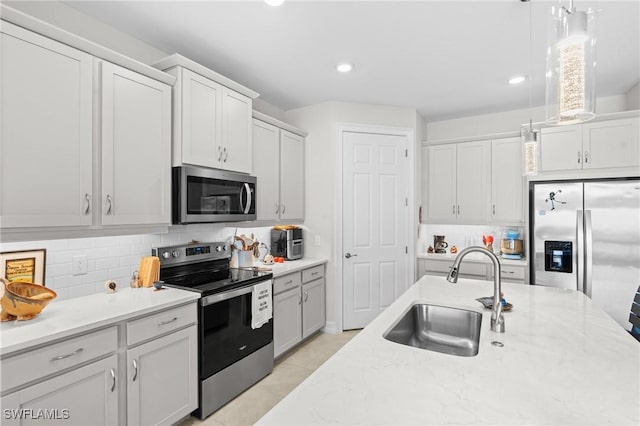 kitchen featuring tasteful backsplash, pendant lighting, sink, appliances with stainless steel finishes, and white cabinets