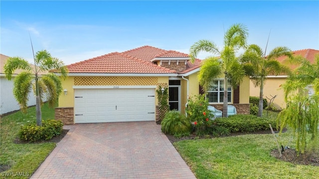 mediterranean / spanish house featuring a garage and a front yard