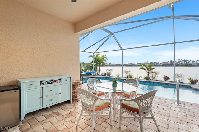 view of patio with a lanai, area for grilling, and a water view