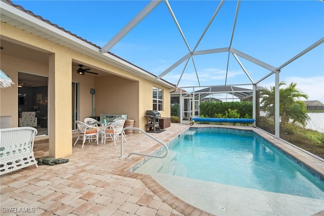 view of swimming pool with ceiling fan, a lanai, area for grilling, and a patio