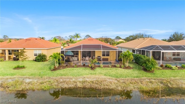 back of property featuring glass enclosure, a water view, a pool, and a yard