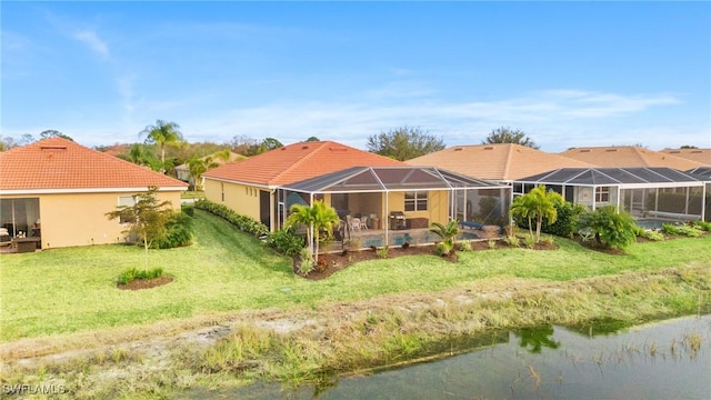 rear view of property featuring a swimming pool, glass enclosure, a water view, and a yard