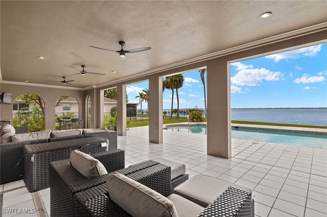 view of patio with ceiling fan, an outdoor living space, and a water view