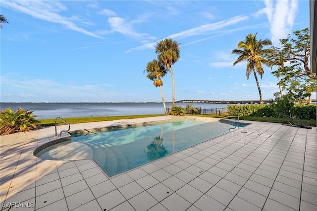 view of swimming pool with a patio area and a water view