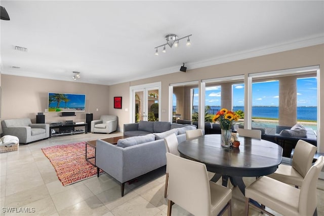 tiled living room with french doors, ornamental molding, and a water view