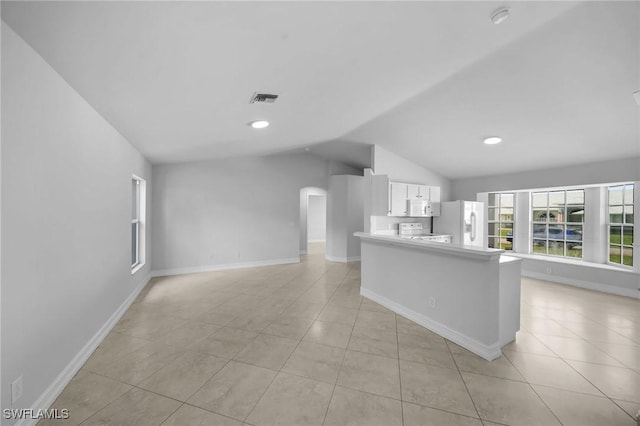 kitchen with white appliances, white cabinetry, light tile patterned flooring, and lofted ceiling