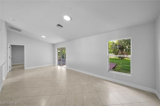 tiled spare room with vaulted ceiling