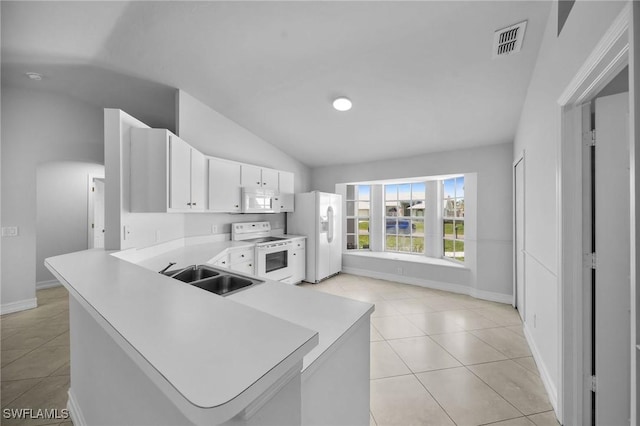 kitchen with white appliances, kitchen peninsula, light tile patterned floors, white cabinets, and sink