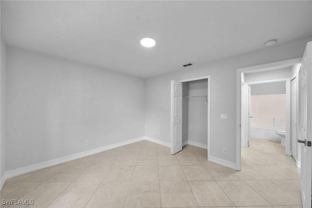 unfurnished bedroom featuring a closet and light tile patterned floors