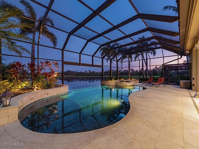 pool at dusk featuring an in ground hot tub, a lanai, a water view, and a patio