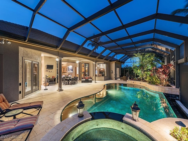 view of pool featuring a lanai, a patio area, and an in ground hot tub