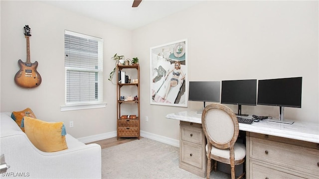 carpeted office with ceiling fan and built in desk