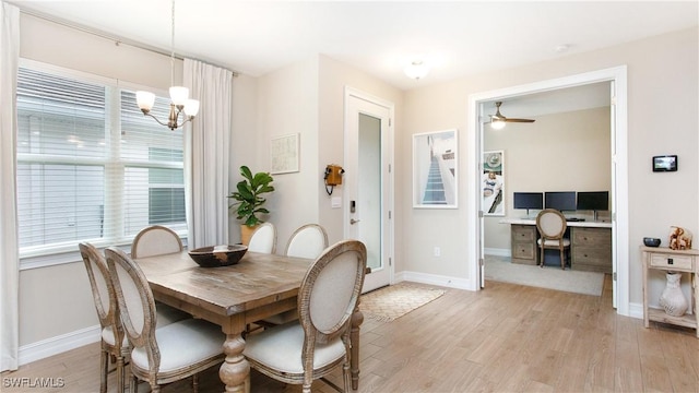 dining area with ceiling fan with notable chandelier and light hardwood / wood-style floors